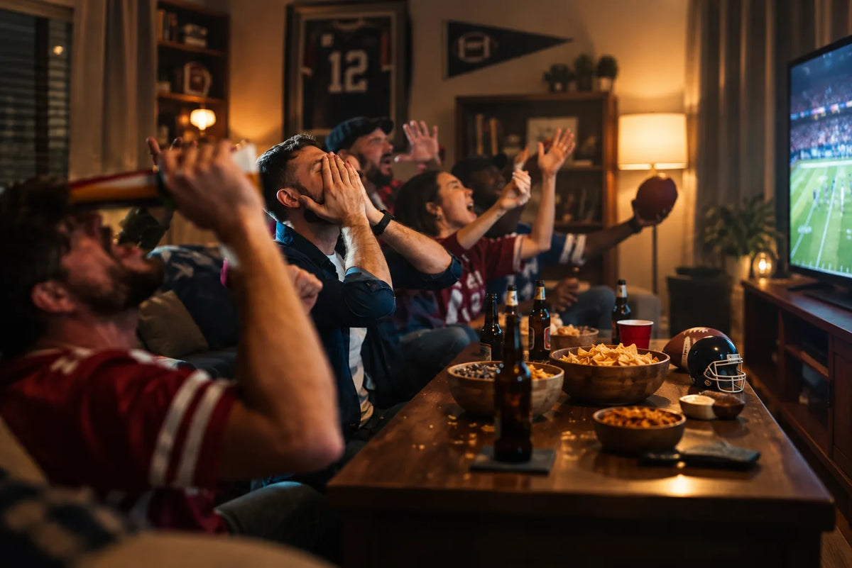 Friends watching football with beer and game day snacks