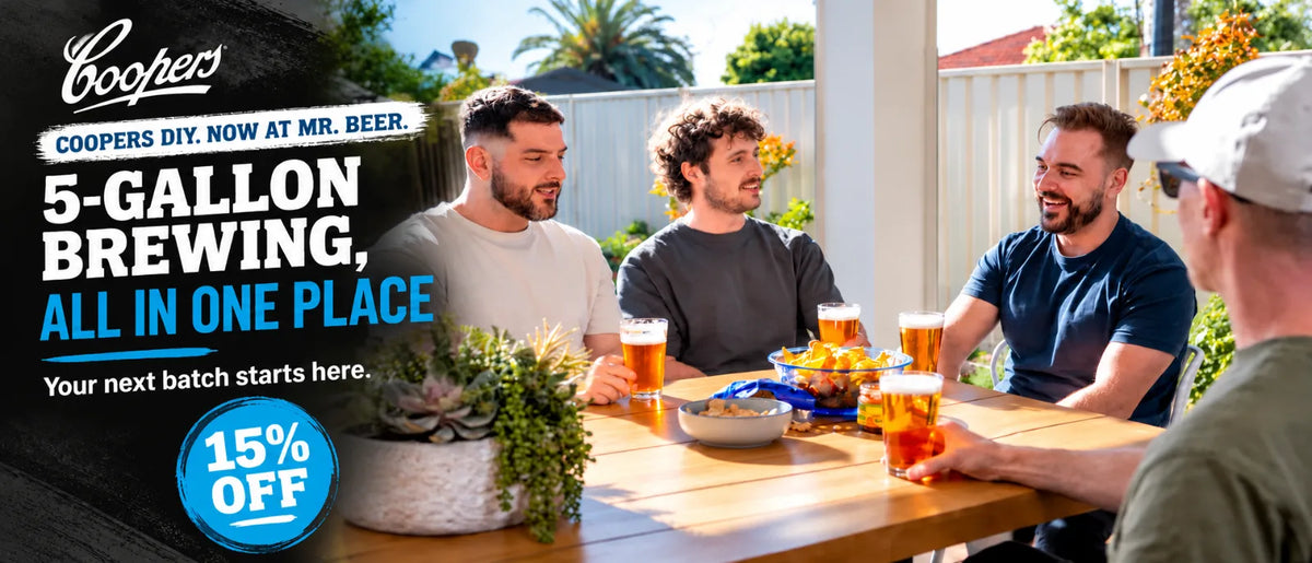 Homebrewer with Coopers DIY 5-gallon brewing kit and fermenter in a modern kitchen with promotional text for the official Coopers DIY launch and 15% off.