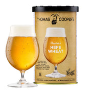 Thomas Coopers Preacher's Hefe Wheat Brewing Extract can with a glass of hazy golden wheat beer