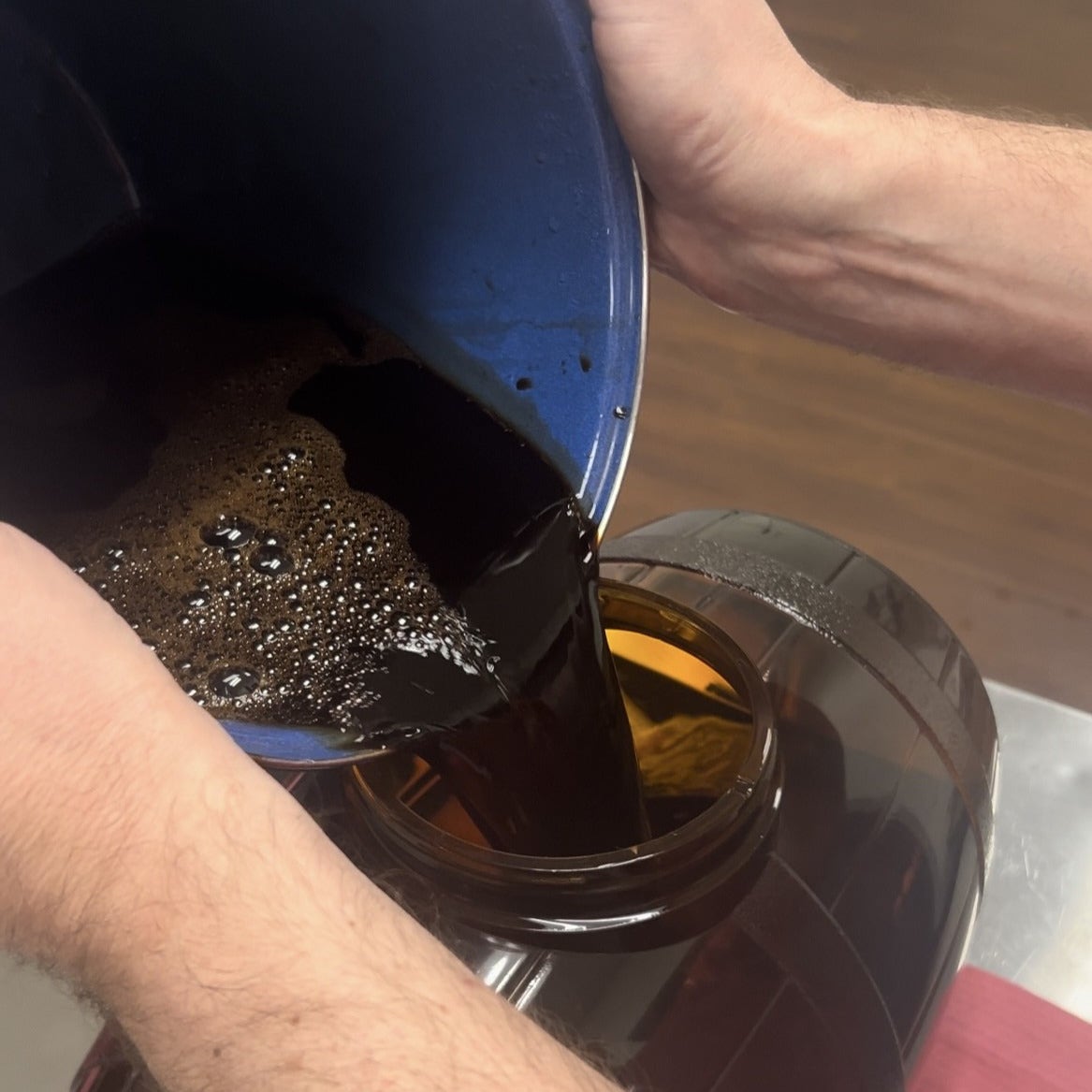 Pouring thick malt extract into a pot